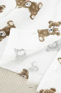 Detail of crinkle gauze cotton pajama fabric with teddy bear print and white buttons
