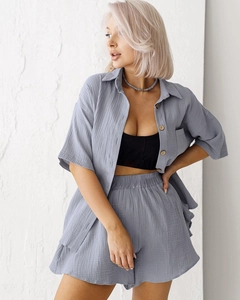 Detail view of cotton pajama set featuring wood buttons and natural wrinkled fabric texture