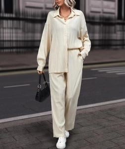 Detailed texture of cream pleated two-piece set featuring fluid drape and soft fabric