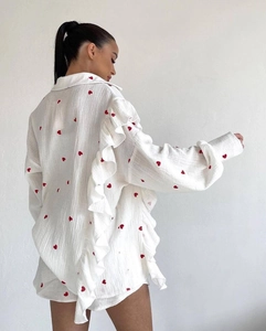 Detail showing white cotton linen fabric with red heart prints and ruffle hem trim