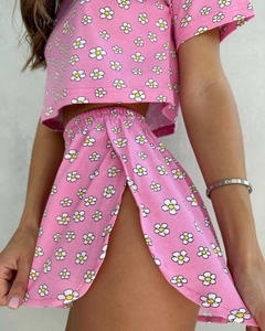 Detailansicht eines rosa Strick-Sets mit Gänseblümchen-Print und Seitenschlitz am Rock