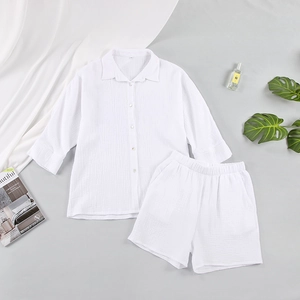 Flat lay of white gauze cotton pajamas set showing breathable seersucker fabric texture