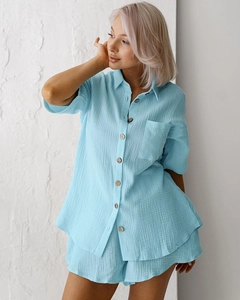 Detail of light blue cotton pajama set showing soft wrinkled texture and wooden buttons