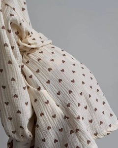 Close-up of soft muslin cotton fabric with heart pattern and ruffle sleeve details