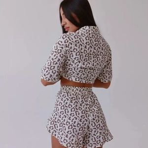 Women's summer two-piece pajama set with leopard print crop top and ruffled shorts