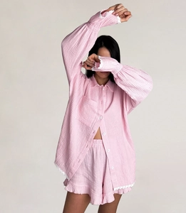 Détails du pyjama en crêpe rose avec bordure en dentelle blanche et boutons sur le devant