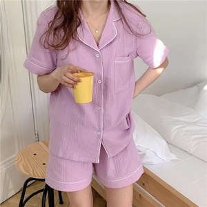 Close-up of lilac seersucker pajamas with white piping and delicate button-up details
