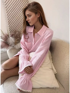 Détail de chemise de détente en crêpe rose avec poignets à volants et bordure en dentelle