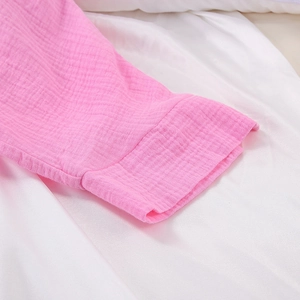 Detailed macro view of pink cotton muslin sleeve cuff with natural crepe texture