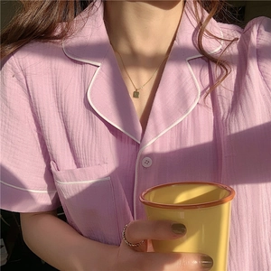 Detail of lavender cotton gauze pajama top featuring white piping and soft texture
