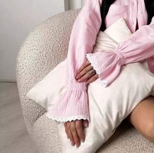 Détail du pyjama en crêpe rose avec manches évasées, dentelle blanche et boutons