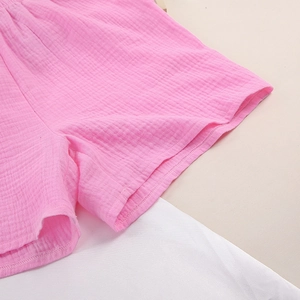 Detail of pink cotton gauze shorts showing textured fabric and elastic waistband
