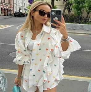 Close-up of white cotton linen loungewear set with colorful heart print and ruffle details