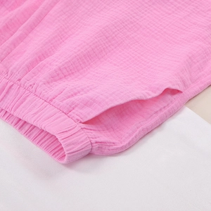 Detail of pink cotton gauze shorts featuring a ruffled elastic waistband and side pocket