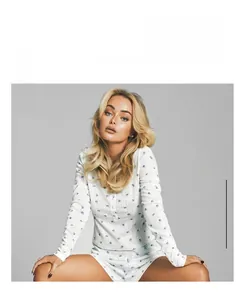 Close-up of white knitted pajamas with delicate blue floral print and soft fabric texture