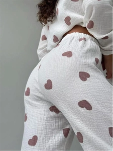 Detailansicht des weißen Baumwoll-Schlafanzugs mit rosa Herzprint und Crinkle-Textur