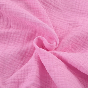 Close-up of soft pink double-layer muslin cotton fabric with natural crinkle texture