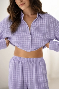 Détail de la texture du pyjama à carreaux violets avec chemise boutonnée et taille élastique