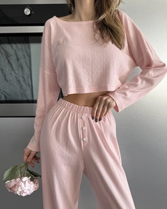 Detail of pink knit pajama set showing subtle hollow jacquard fabric and waist buttons
