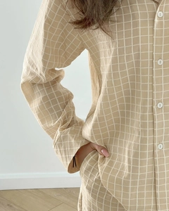 Detail of waffle textured beige plaid pajamas featuring a button-down shirt and long pants