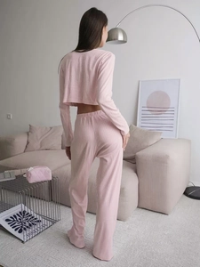 Detail of pink knitted ribbed loungewear set featuring crop top and wide-leg trousers