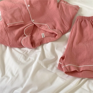 Close-up of pink cotton gauze pajama set with white piping and textured fabric