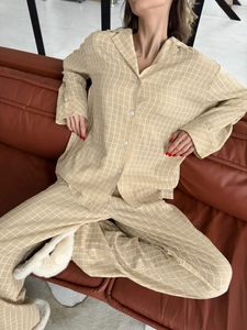 Detail of beige windowpane plaid pajamas fabric and button-up shirt texture