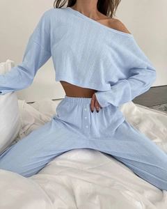 Detail view of light blue knitted fabric texture and decorative buttons on pajama set