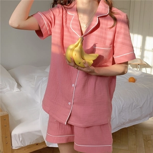 Detail of pink muslin cotton short sleeve pajamas with white piping and chest pocket texture