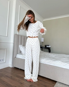 Détail d'un ensemble pyjama à imprimé cerise avec bords à volants et boutonnage
