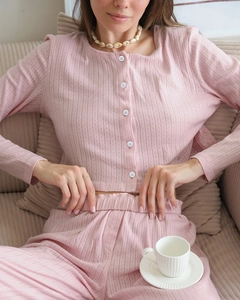 Detail of pink knitted loungewear set featuring soft hollow texture and white buttons