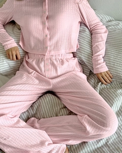 Detail view of pink ribbed knit pajamas showing soft texture and button cardigan top