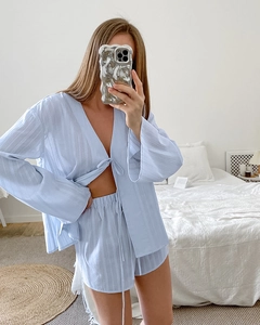 Detail of light blue pleated long sleeve pajama top with tie-front and matching shorts