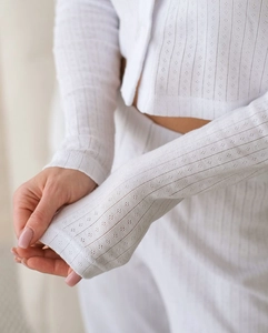 Detail of white pointelle knit pajamas showing texture and breathable hollow-out pattern