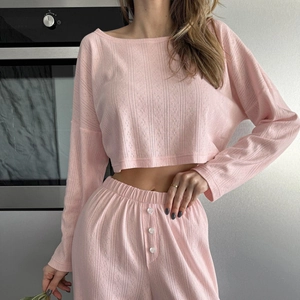 Pink knit lounge set featuring a long sleeve crop top and matching pants in soft fabric