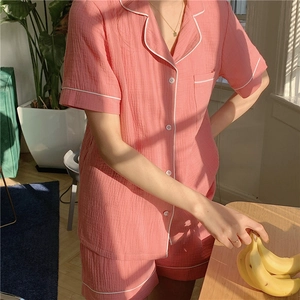 Detail of pink cotton gauze pajama set with white piping and textured fabric