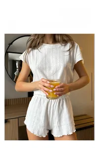 Dettaglio del set loungewear in maglia bianca con trama a costine traspirante e pantaloncini