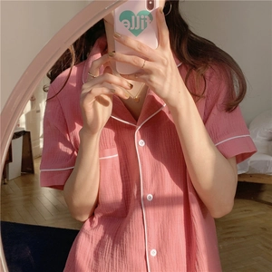 Detail view of pink gauze cotton pajamas with white piping and textured fabric