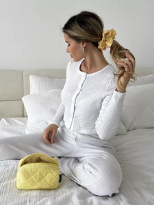 Detail of white ribbed knit loungewear set with yellow checkered scrunchie and quilted pouch