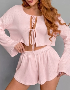 Detail of light pink knit pajama set featuring delicate diamond texture and tie-front design