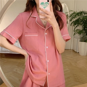 Close-up of pink gauze pajama set with white contrast piping and chest pocket details
