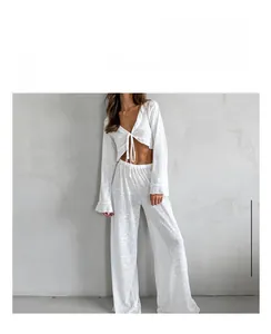 Detail of white two-piece knit pajama set featuring a tie-up top and wide-leg pants
