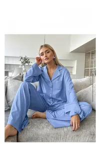 Detail of light blue satin pajama set featuring a button-down shirt and wide-leg trousers