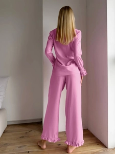 Detail view of pink ruffled sleeves and pants on a soft long-sleeve pajama set
