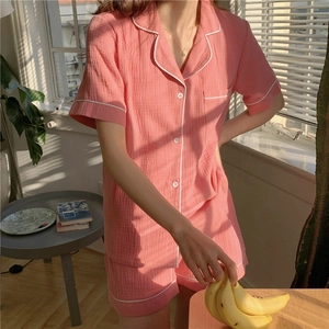 Pink cotton gauze pajamas set with white piping and short sleeves in soft sunlight