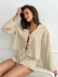 Close-up of beige tie-front long sleeve top with ruffled shorts loungewear set