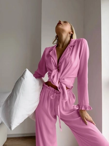 Detail of pink ruffle cuffs and tie-waist on long-sleeve silk-feel pajama set for women