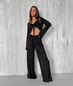 Detail of black two-piece knit pajama set with long sleeve tie-front top and wide-leg pants