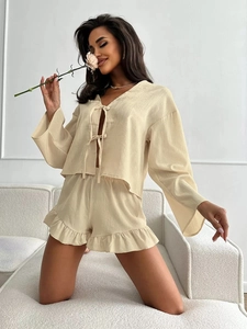 Detail of ruffled shorts and tie-front long sleeve pajama set in cozy beige fabric