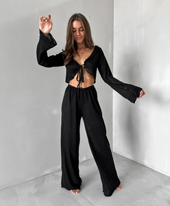 Detail view of black knit lounge set featuring tie-front cardigan and wide-leg trousers